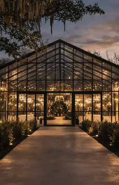 glass house wedding venue at night with lights