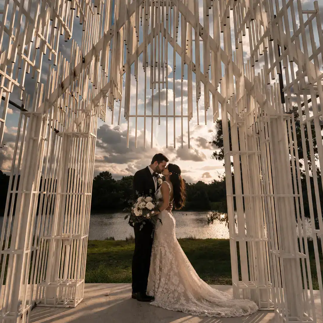 couple kiss at contemporary outdoor wedding venue near houston ivory arches